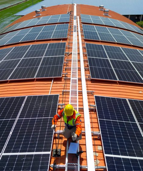 engineer man inspects construction of solar cell panel or photovoltaic cell at roof top.
